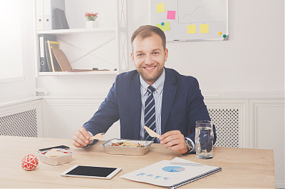 男人在现代的办公室里吃健康的商务午餐图片下载