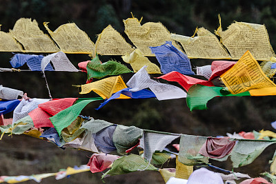 冬季，拉钦的坦古和乔普塔山谷，在冰封的河流上，撕裂飘扬的五彩藏族经幡和裹在桥上的经幡。北锡金,印度。图片下载