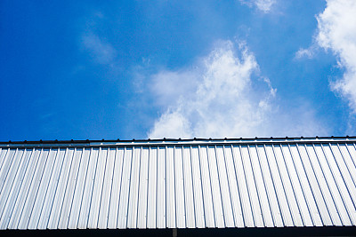蓝天白云下的工厂或仓库的墙壁和屋顶图片下载