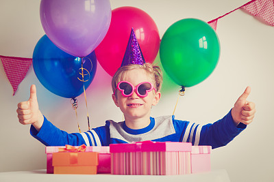 生日聚会上，快乐的男孩带着礼物图片下载