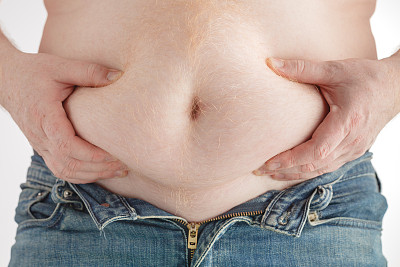 一个胖子在白色背景下检查自己的体重图片下载