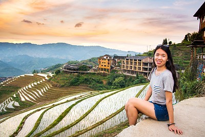 在中国龙脊梯田，女孩欣赏日落素材图片