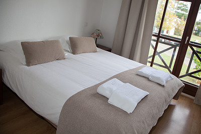 卧室里的双人床，旁边有台灯图片下载