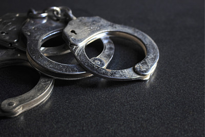警察手铐在黑暗的背景与复制空间，过光[模糊和选择焦点背景]图片下载