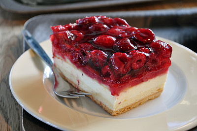 奶酪蛋糕与新鲜的树莓在一个白色盘子上特写。图片下载