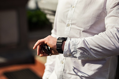 商人时钟衣服，商人检查他的手表时间。男人的手上有手表，男人的手上有手表，新郎的费用，准备工作，系好钟表的时间，男人的风格，纠正袖子的风格感图片下载