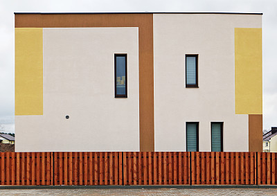 在木栅栏后面有一堵墙，是一个正在建设的大规模农村生产房屋。鲜艳的颜色应该能吸引买家。多云的春天图片下载