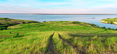 从山顶俯瞰美丽的海景。美丽的夏天的背景。黄色的草地，绿色的树木，蓝天，陡峭的悬崖和风景如画的海湾。全景照片。野营的时候,休息,放松。图片下载
