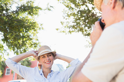 快乐的年长妇女摆姿势为她的伙伴拍照图片下载