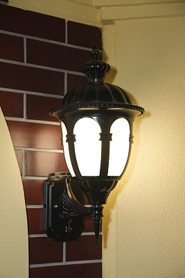 小镇或乡村花园外、街道墙壁上的老式金属电灯。图片下载