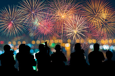 记者的剪影拍摄了奇异的节日新年色彩斑斓的烟花在城市景观上模糊不清的照片散景，项目成功，假日概念图片下载