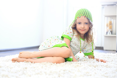 可爱的女孩绿帽子白地毯图片下载