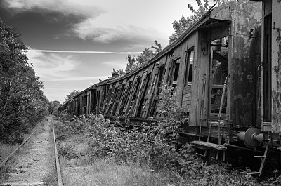 无望的后世界末日景象。废弃的破火车墓地。黑白照片。图片下载