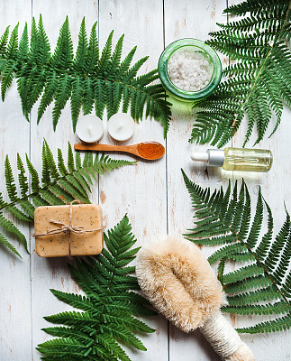 穆迪水疗中心桌子上方的照片。芳香疗法。Spa设置蕨与石头，盐碗，油，毛巾，蜡烛在灰色的背景图片下载