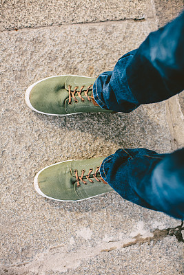 穿着牛仔裤和运动鞋的时髦旅行者图片下载