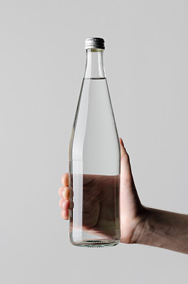 水瓶模型-在灰色的背景下，男性的手拿着一个水瓶图片下载