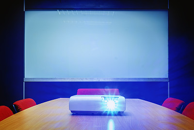 会议室的桌子上放着投影仪发出的蓝光图片下载