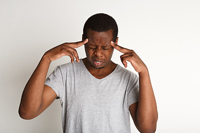 一名专注沉思的黑人，手指放在太阳穴上图片下载