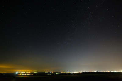 街道灯光下城市夜空中的星星。图片下载
