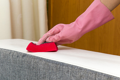 皮革沙发用海绵化学清洗。家具清洁。春季大扫除。图片下载