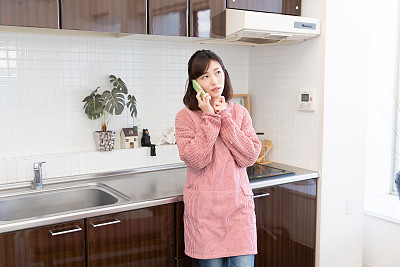 在厨房里打电话的女人图片下载