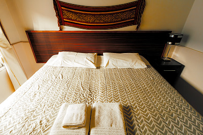 房间的床上放毛巾，墙上挂着一张挂毯图片下载