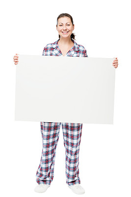 穿着睡衣的快乐女人在白色背景前举着一张巨大的海报图片下载