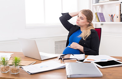 疲惫的怀孕女商人在办公室复印室图片下载