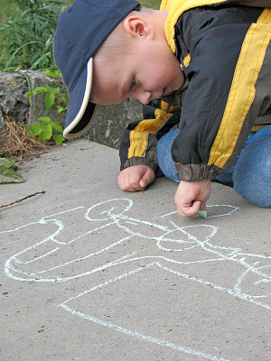 孩子在沥青上用粉笔画画图片下载
