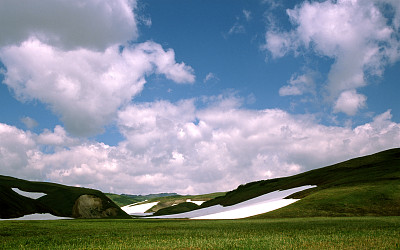 白雪落在绿色的田野上图片下载