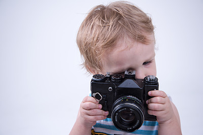 男孩用黑色旧相机拍照图片下载