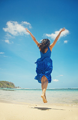 海滩上穿蓝裙子的女人图片下载