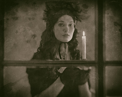 旧的湿盘子照片维多利亚妇女在黑色连衣裙站在窗前拿着烛台。图片下载