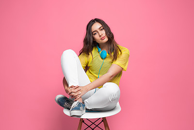 坐在椅子上戴着耳机的年轻人素材图片