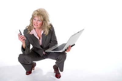 女商人同时使用手机和笔记本电脑图片下载