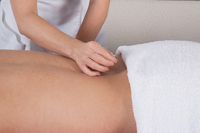 一个手放置针灸针在人的背上的特写图片下载