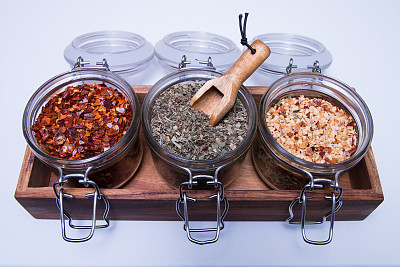 混合不同的香料在玻璃瓶隔离白色图片下载