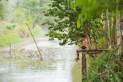 小男孩在湖上钓鱼。图片下载