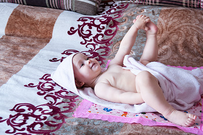 小女孩洗完澡躺在一条毛巾里图片下载