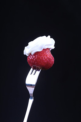 银叉上鲜嫩草莓和鲜奶油。有选择性的重点。图片下载