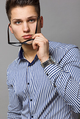 穿着条纹衬衫的年轻人摘掉了眼镜图片下载