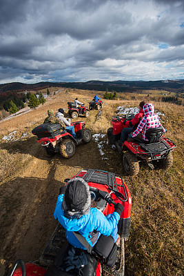 在晴朗的秋日，一群人骑着一辆atv在一条山路下的天空与云图片下载