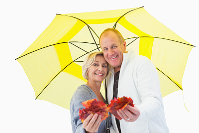 幸福成熟的夫妇在伞下展示秋天的叶子图片下载