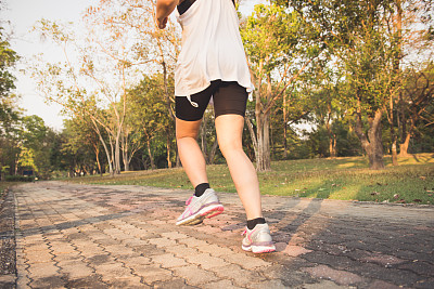 年轻女子在树林里跑步，训练和锻炼晨跑马拉松耐力。健身健康的生活方式理念。复古效果风格的图片。图片下载