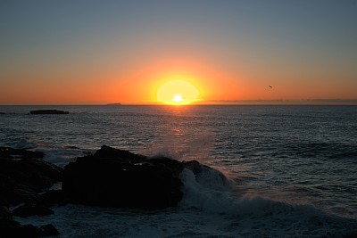日出在海滩。清晨日出的海岸有岩石。可见的是黎明的裂缝，晨光，岩石和海浪图片下载