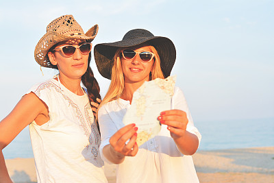 两个女孩在公路旅行中使用地图图片下载