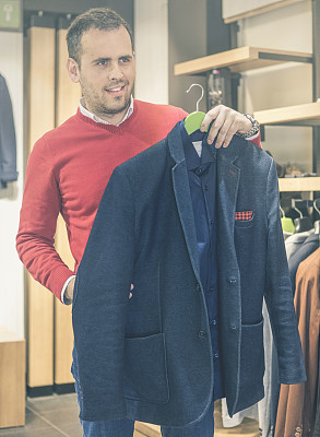 快乐的年轻人在商场或服装店挑选夹克。销售，购物，时尚，风格和人的理念。图片下载