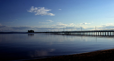 黄昏中长长的防波堤，平静的水面素材图片