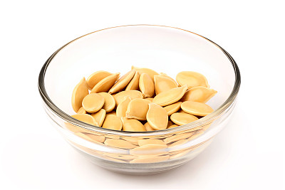 把南瓜籽放在玻璃碗里。孤立的特写镜头。图片下载