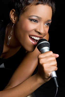 一个女人对着麦克风唱歌的特写照片图片下载